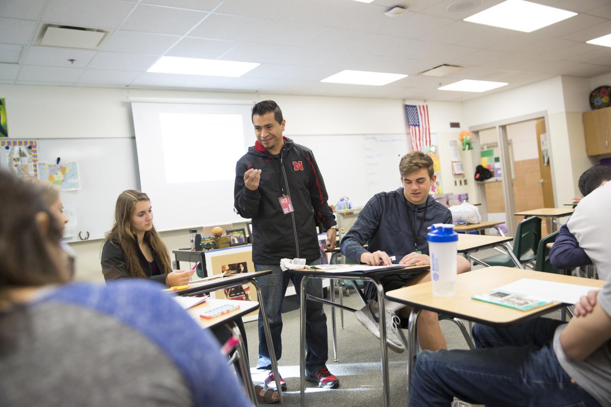 Teenagers sit talking with an instructor in a classroom