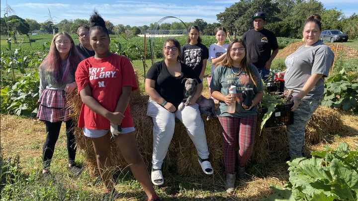 Nine young people pose for a group photo near a teaching farm on the University of Nebraska–Lincoln's East Campus.