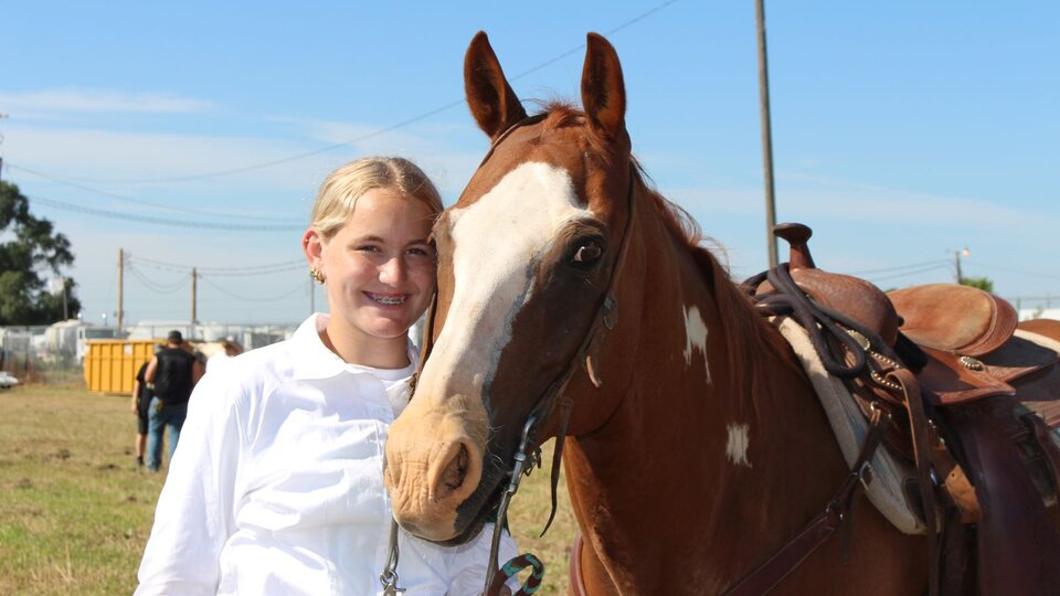girl standing next to horse
