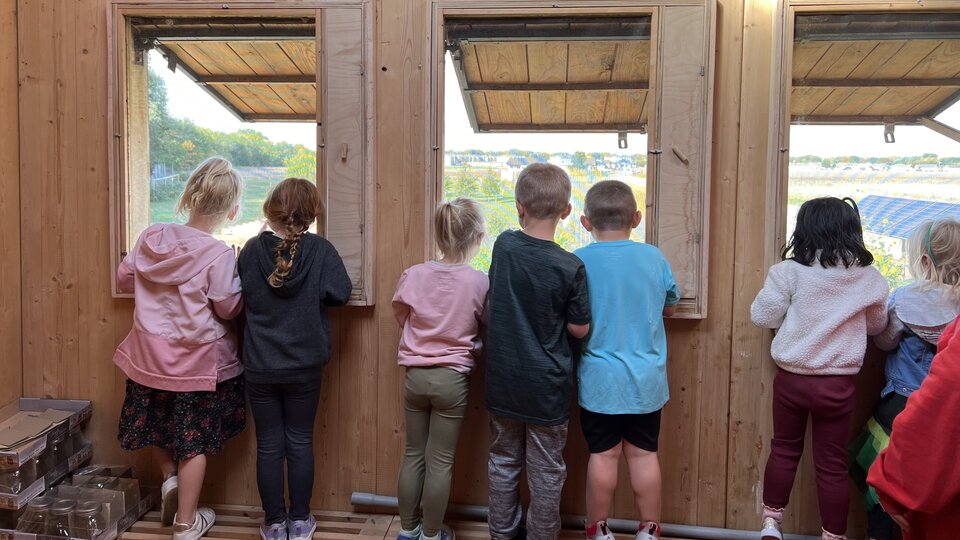 youth looking out building at orchard