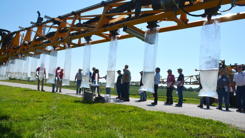 Ag Producers looking at irrigated pivot water collection in bags.