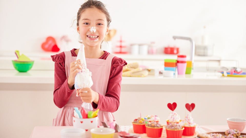 Girl baking and decorating cupcakes for a 4-H project