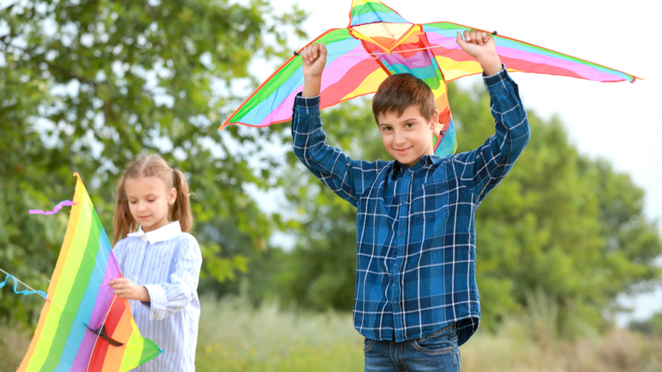 A boy and a girl get ready to fly kites
