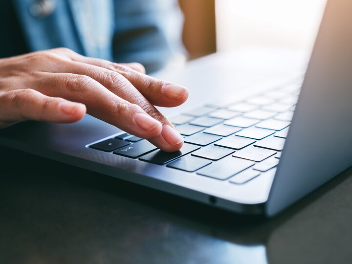 Fingers typing on keyboard of computer