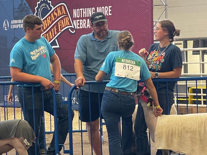 4H family chatting while waiting to show lamb at fair