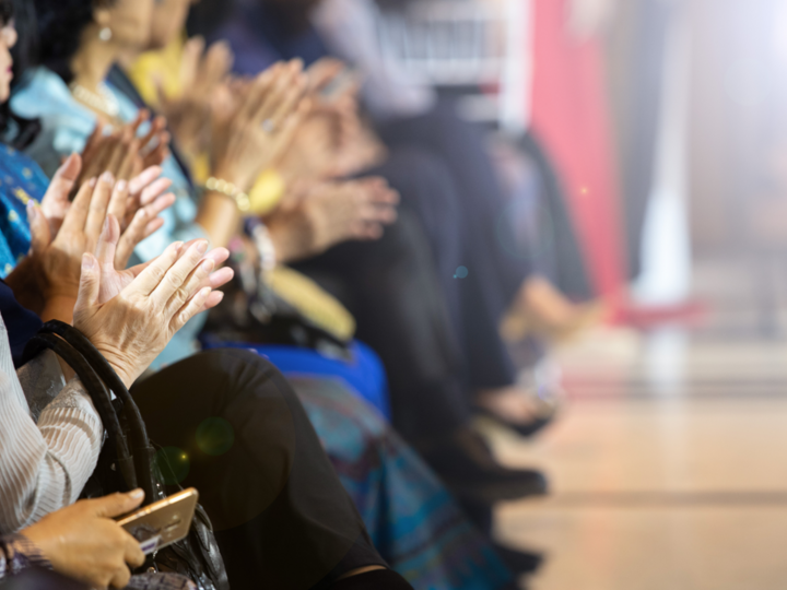 People sitting in a line clapping