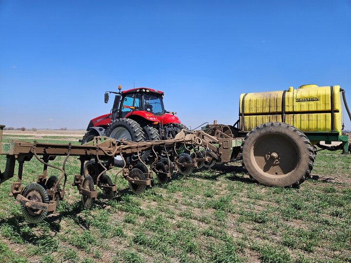 Red Tractor with Planter attachment sewing a field