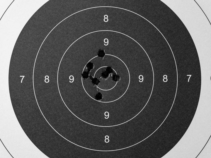 Shooting target with holes surround bullseye