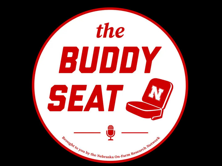 The Buddy Seat logo with red text, a seat icon, and a microphone beneath.