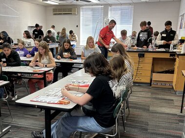 Students sit at desks while at Connecting the Dots