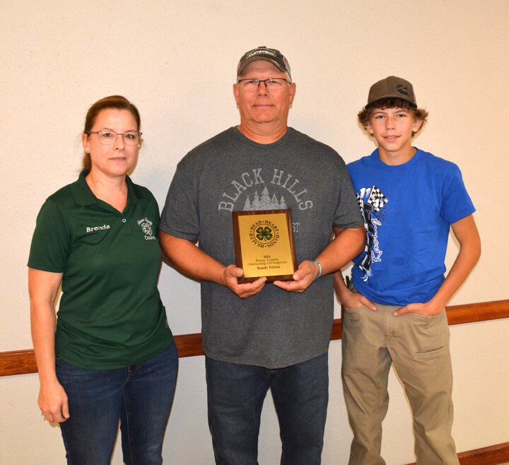Randy Pelster receives Friend of 4-H award, Brenda and Kahnen with him