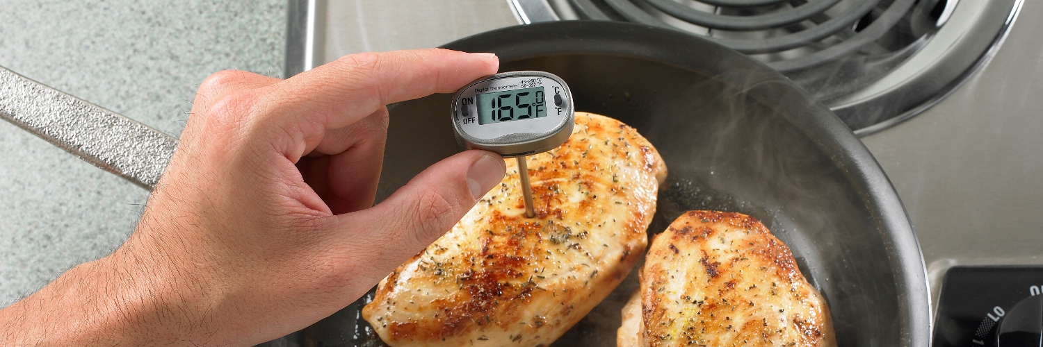 checking the temperature of grilled chicken